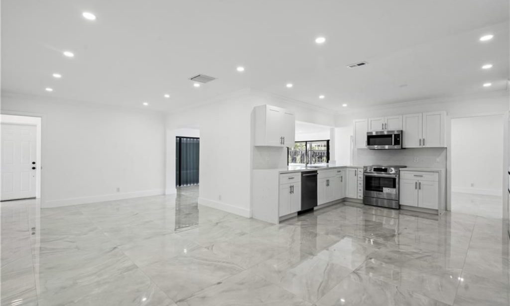 Remodeled kitchen in Miami, full view, including all white fixtures, walls, and ceilings.  Another angle of remodeled kitchen in Miami by NXT Construction