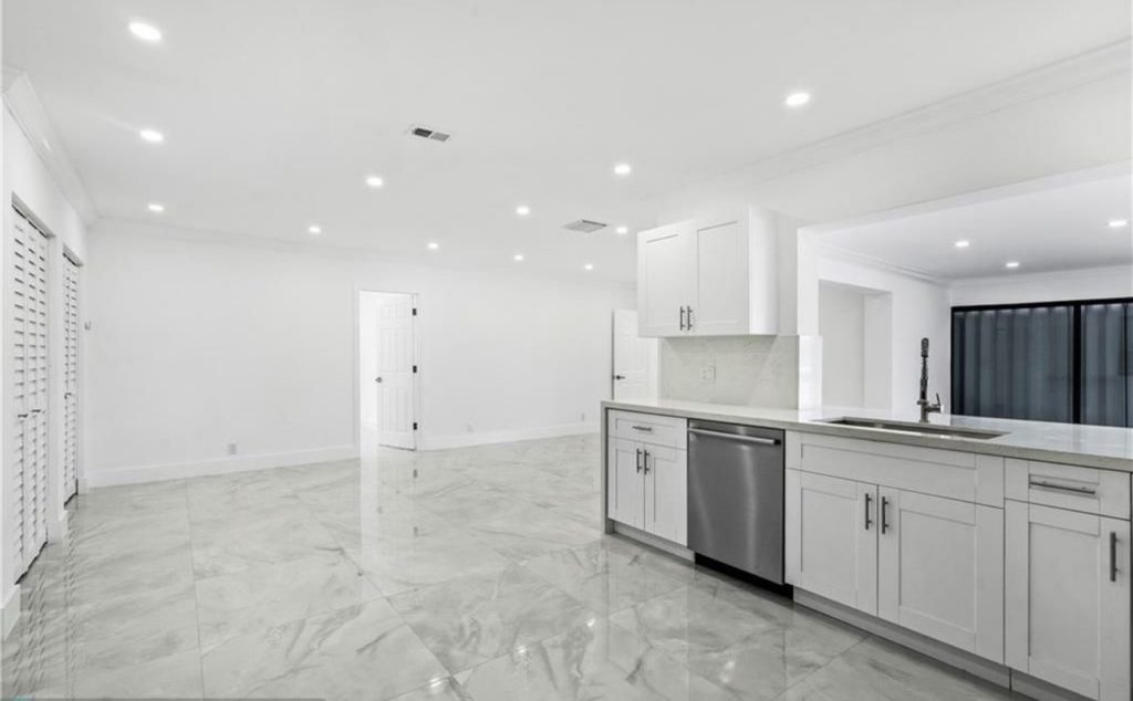 Remodeled kitchen in Miami, full view, including all white fixtures, walls, and ceilings.  Another angle of remodeled kitchen in Miami by NXT Construction